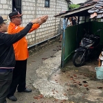 Kepala Desa Socorejo, Zubas Arief Rahman Hakim, saat meninjau rumah warga yang rusak akibat hujan deras disertai angin kencang.