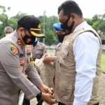 Tampak AKBP Dony Alexander Kapolreskab Mojokerto sedang memakaikan rompi pada Tim Khusus Anti Mony Politics.