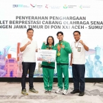 Direktur Keuangan dan Umum Petrokimia Gresik, Robby Setiabudi Madjid (kiri), ketika memberikan bonus kepada atlet senam. Foto: Ist