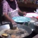 Ibu-ibu yang menggemparkan dunia maya karena membolak balikkan gorengan dengan tangan kosong. foto via merdeka.com