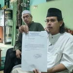Juru Bicara Ahli Waris Wakif Masjid Al-Muttaqun Rahmat Mahmudi didampingi Ustadz Arman, saat menunjukkan surat dari BWI Kota Kediri. Foto: MUJI HARJITA/ BANGSAONLINE