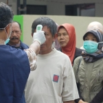 Proses pengecekan suhu tubuh di Kantor Kejari Trenggalek. foto: HERMAN/ BANGSAONLINE