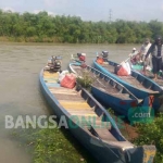 Masyarakat tetap beraktivitas melakukan penyeberangan dengan perahu kayu meski kondisi air Sungai Bengawan Solo sedang naik. foto: EKY NURHADI/ BANGSAONLINE