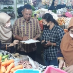 Petugas saat mengecek komoditas di pasar tradisional. Foto: Ist.