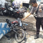 Petugas menunjukkan motor korban yang tampak ringsek usai dihantam pikap.