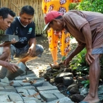 Warga menunjukkan pemasangan paving yang amburadul.