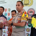 Kapolres Blitar AKBP Anissulah M Ridha menunjukkan barang bukti berupa uang tunai. foto: AKINA/ BANGSAONLINE