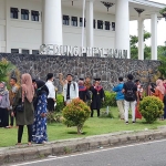 Wisudawan-wisudawati saat mengambil foto di depan logo Gedung UTM, Rabu (25/11/2020).