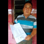 Koordinator aksi Wijiantoro menunjukan surat bukti mengembalikan stempel ke pemerintah desa Sidomulyo.?