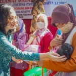 Ketua Tim Penggerak PKK Kabupaten Kediri Eriani Annisa Hanindhito saat mengelus dengan lembut kepala seorang bayi yang digendong ibunya. Foto: Ist.