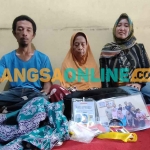 Salami, JCH Kloter 32 dari Kota Kediri yang minta pulang saat diapit oleh kedua anaknya, Umi Hanafiah dan Khoirul. Foto: MUJI HARJITA/ BANGSAONLINE