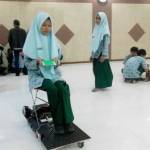 TEST DRIVE: Siswa Smamda Sidoarjo, Shafira QS, mencoba prototipe kendaraan elektrik berbasis android, di Aula Smamda, Rabu (26/10). foto: mustain/ bangsaonline