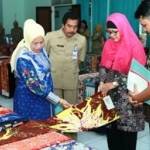 Ketua Dekranasda Lamongan, Mahdumah Fadeli (berbaju biru)  kagumi hasil batik khas Lamongan. (Haris/BANGSAONLINE)