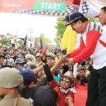 Gubernur Jawa Timur Dr. H Soekarwo saat menyapa para peserta Gerak Jalan Perjuangan Mojokerto - Surabaya yang diikuti belasan ribu orang.