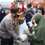 Kapolres Mojokerto, AKBP Dony Alexander saat menyerahkan bantuan sembako ke salah satu warga.