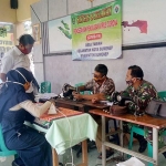 Babinsa Desa Pabian saat membantu pembuatan masker kain.