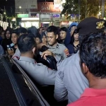 Aparat menjaga Ahmad Husein dari amukan massa. Foto: ist.