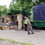 Petugas Polsek Tandes dibantu Satpol PP sedang melakukan pengamanan di lokasi truk terguling. foto: NANANG FACHRUROZI/ BANGSAONLINE