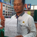 Kepala Sekolah SMPN 3 Srengat Heri Sasmito sedang menunjukkan surat kaleng yang diterima pihak sekolah.