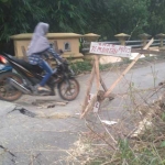 Salah seorang warga nekat melintasi jembatan yang terputus. foto: AHMAD/ BANGSAONLINE