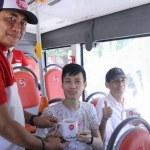 Kepala Dishub Kota Surabaya Irvan Wahyudrajad saat memberikan suvenir kepada penumpang Suroboyo Bus. foto: ist