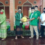 Hj. Anisah dan putranya saat menyalurkan bantuan secara simbolis kepada pengurus Muslimat disaksikan Camat dan Muspika Rembang.