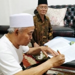 Dr. KH. Asep Saifuddin Chalim, MA menandantangani penyerahan tanah wakaf Markas Besar  Oelama (MBO) Jawa Timur di Guest House Institut KH. Abdul Chalim Pacet Mojokerto Jawa Timur, Rabu (13/11/2019). foto: BANGSAONLINE.com