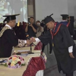 Rektor Universitas Trunojoyo Madura, Safi, saat mewisuda salah satu mahasiswa.