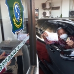 MUDAH: Sekda Zaini mencoba Drive Thru Pembayaran Pajak Daerah di MPP Sidoarjo, Selasa (10/8/2021). (foto: MUSTAIN/BANGSAONLINE)