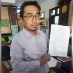 Taufan Rezza, S.H., M.H. kuasa hukum Sekda Andhy Hendro Wijaya menunjukkan bukti  pendaftaran praperadilan di PN Gresik. foto: ist.