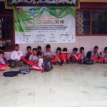 Siswa kelas 1A dan 1B SDN Jember Lor 5 harus belajar di luar kelas akibat kelasnya kebanjiran.