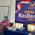 Salah satu peserta vaksinasi massal Partai NasDem sedang disuntik petugas. (foto: ist)