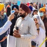 Perawat memeriksa suhu peziarah di pintu masuk Kuil Emas di Amritsar, India. foto: AFP via Getty Images