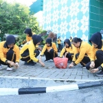 Pegawai perempuan Polres Gresik saat membersihkan lingkungan Masjid Agung Maulana Malik Ibrahim. (Ist)