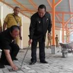Wakil Wali Kota Suyitno memeriksa ketebalan sirtu paving pasar Kliwon yang dianggap kurang miring. foto: YUDI EP/ BANGSAONLINE