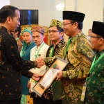 Presiden RI, Joko Widodo, menyerahkan sertifikat pemberdayaan kepada Bupati Tuban, Fathul Huda.