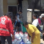 Warga saat antre air bersih yang dibagikan petugas dari PMI Jember.