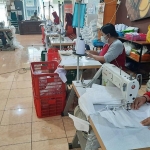 Para pekerja UMKM sedang mengerjakan pembuatan masker dan APD.