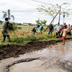 Anggota Babinsa bersama warga Desa Rejuno sedang bergotong royong membersihkan aliran sungai/parit.