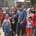 Wali Kota Kediri Abdullah Abu Bakar saat ikut jalan sehat dan menyapa seorang anak. Foto: Ist.