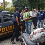 Tersangka (rompi hijau) saat hendak dilimpahkan ke Kejari Kota Malang dengan pengawalan Anggota Sabhara Polresta Malang Kota.