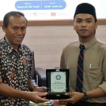 Rektor UNP Kediri, Dr. Zainal Afandi, M.Pd (kiri), saat menyerahkan cendera mata kepada akademisi asal Malaysia, EN. Izharulhak Saiful Hafni. Foto: Ist
