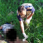 Petugas Polres Gresik saat mengidentifikasi mayat yang ditemukan di selokan Tol Kebomas. foto: ist.