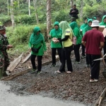 Ibu-ibu Persit KCK Cabang XX Kodim 0806 Trenggalek saat membagikan bubur kacang hijau kepada Satgas TMMD dan warga.