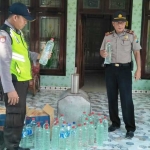 Petugas saat mengamankan miras jenis arak dari rumah STM. foto: SUWANDI/ BANGSAONLINE
