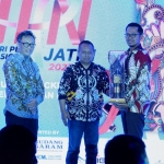 Ketua PWI Jatim Lutfil Hakim ketika menyeahkan penghargaan ‘PWI Jatim Award’ pada Direktur PT Petrogas Jatim Utama (Perseroda) Buyung Afrianto dalam peringatan HPN tahun 2023 di Kota Kediri.