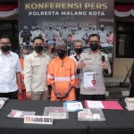 Kapolsek Kedungkandang Kompol Agus Siswo (kanan) menunjukkan buku rekapan togel yang diamankan dari salah satu tersangka.