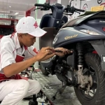 Mekanik AHASS saat sedang memeriksa motor yang mengalami brebet.