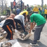 Warga Desa Socah dan Pataonan bergotong royong membersihkan sampah yang menumpuk di pinggir jalan.