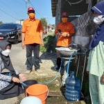 Bupati Mojokerto melayani pemberian air bersih kepada warga Desa Duyung. (foto: ist)